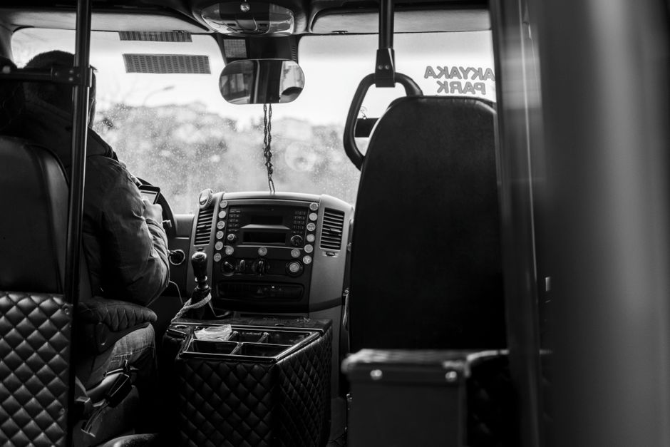 Een buschauffeur rijdt door Nissewaard met passagiers aan boord, kleurrijke omgeving en drukke straten.
